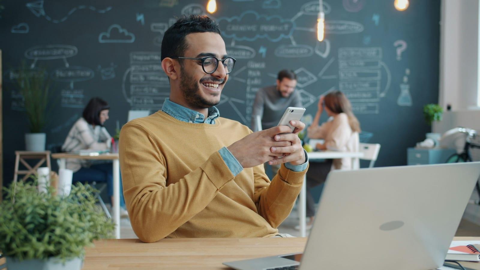 Satisfied business owner smiling while checking business finances and paid invoices.
