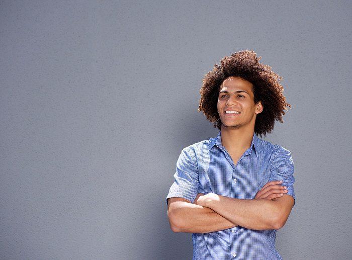 smiling confident man standing with arms crossed